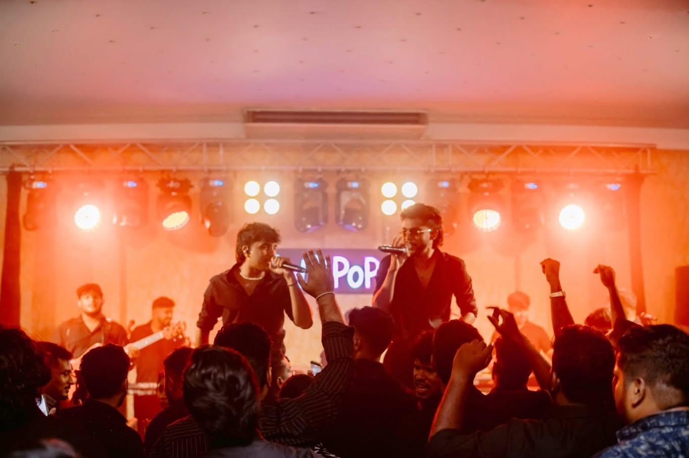 A crowd with hands up in front of the band
